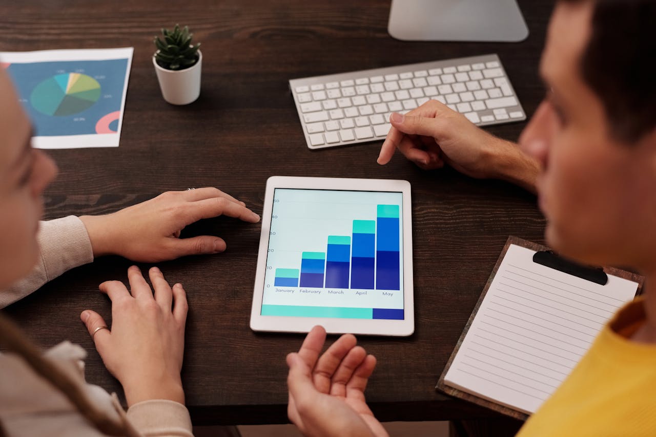 about-01 Team members discussing digital graphs on a tablet in a modern office setting.